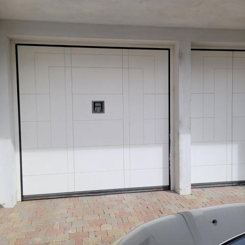 two large white garage doors in a building at Carlotta Mountain Lake Iseo Hospitality in Bossico