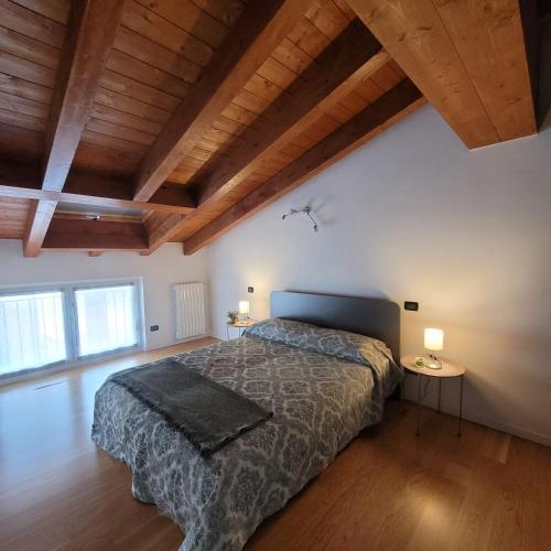 a bedroom with a bed and a wooden ceiling at Carlotta Mountain Lake Iseo Hospitality in Bossico