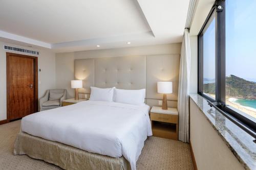 a bedroom with a bed and a large window at Hilton Copacabana Rio de Janeiro in Rio de Janeiro