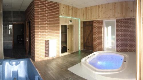 ein großes Bad mit einer großen Badewanne in einem Zimmer in der Unterkunft Hotel Agat & SPA in Bydgoszcz