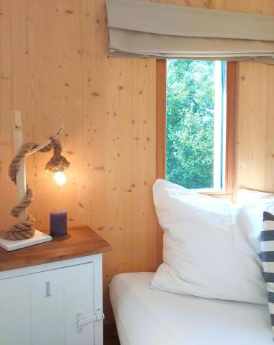 a bedroom with a bed with a window and a lamp at Tiny Haus "Mrs Green" - Boutique Loft Nina&Susanne in Drosendorf Stadt