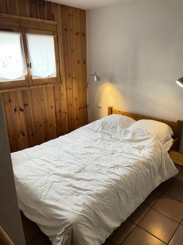 - un lit blanc dans une chambre avec une lampe dans l'établissement Résidence Les Jardins Alpins - Jardins Alpins B03 MAE-5231, à Saint-Gervais-les-Bains