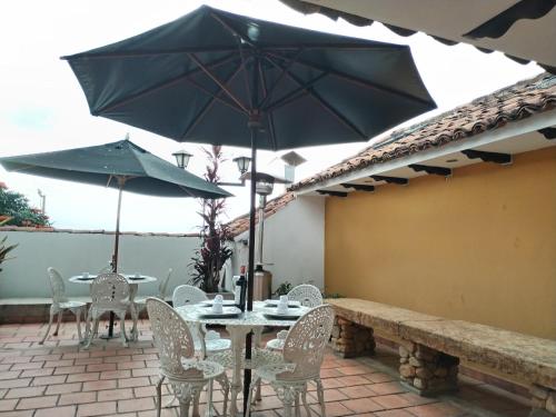 a table and chairs with umbrellas on a patio at Santa Maria de Leyva hotel boutique in Villa de Leyva