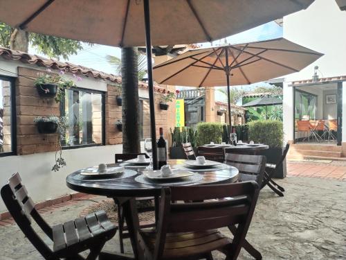a table and chairs with umbrellas on a patio at Santa Maria de Leyva hotel boutique in Villa de Leyva