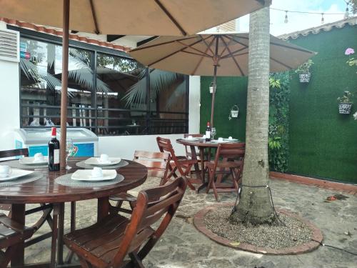 a patio with tables and chairs with an umbrella at Santa Maria de Leyva hotel boutique in Villa de Leyva