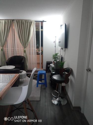 a living room with a table and chairs and a tv at DeptoIquique in Iquique