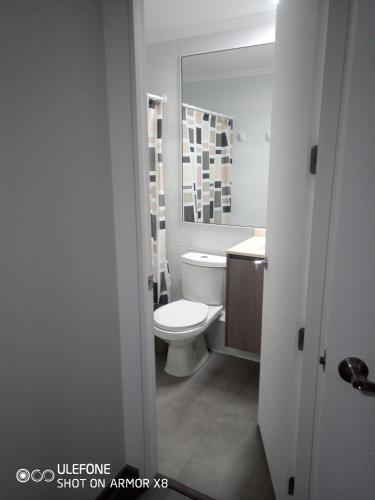 a white bathroom with a toilet and a sink at DeptoIquique in Iquique