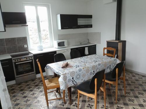 a kitchen with a table and some chairs and a table and a kitchen with at Maison sud Ardèche lavilledieu in Lavilledieu