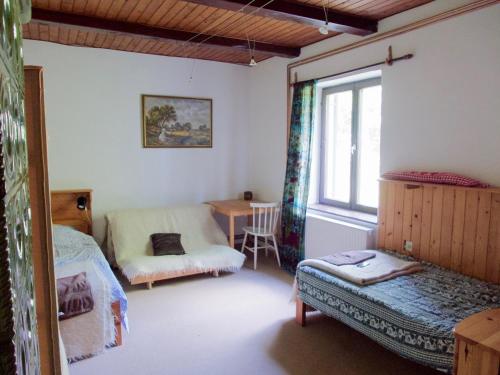 Schlafzimmer mit einem Bett, einem Tisch und einem Fenster in der Unterkunft Hétrét Vendégház in Kercaszomor