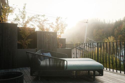 a bed sitting on a deck with a fence at Refugium Lunz in Lunz am See