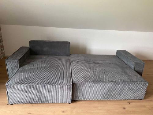 a metal couch sitting on a wooden floor at Ferienwohnung Auf der Höhe in Erbach im Odenwald