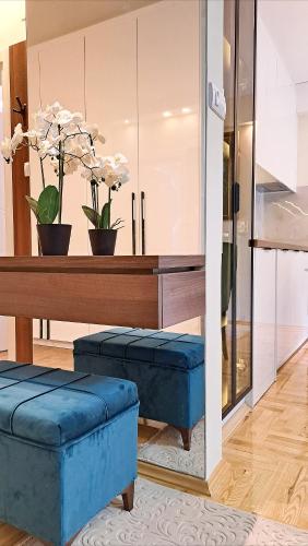 a living room with blue stools and a table at Jacuzzi Life in Subotica