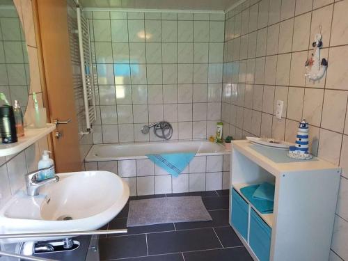 a bathroom with a sink and a tub and a sink at Country House East Frisia in Großheide