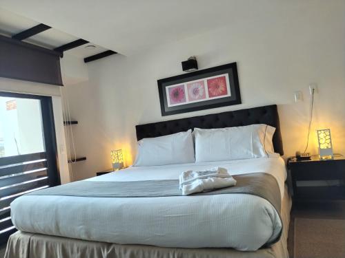 a bedroom with a large bed with white pillows at Santa Maria de Leyva hotel boutique in Villa de Leyva