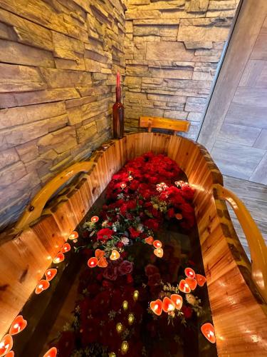 a table filled with red flowers in a room at Rokwood faraya in Ash Sha‘rah