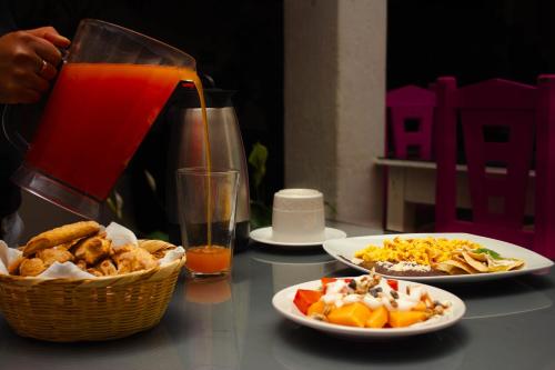 una mesa con platos de comida y una jarra de zumo en Jardines de Luz, en San Cristóbal de Las Casas