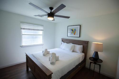 a bedroom with a bed with white sheets and a ceiling fan at Onyx Hotels in Austin