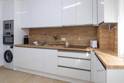 a kitchen with white cabinets and a sink at Casa Callejón de las Morenicas in Cazorla