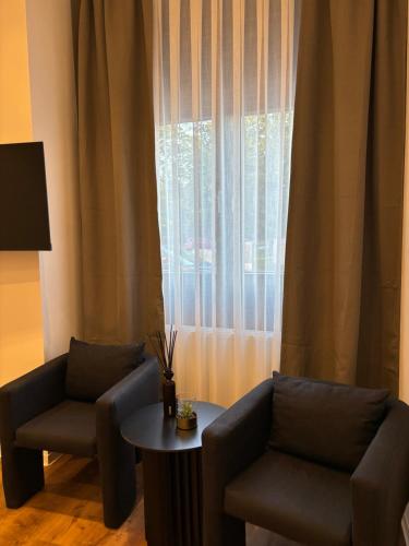 a living room with two chairs and a table and a window at Schwentine Suite in Kiel