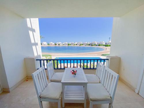 a table and chairs on a balcony with a view of the beach at Nayah Stays, Joubal Lagoons flowery apartment in Hurghada