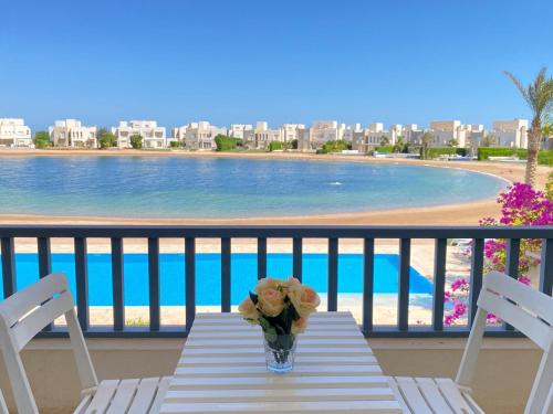 a table with a vase of flowers on a balcony at Nayah Stays, Joubal Lagoons flowery apartment in Hurghada