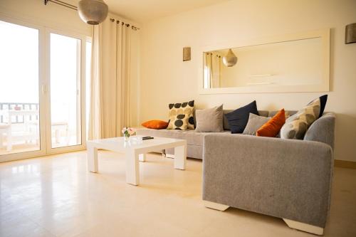a living room with a couch and a table at Nayah Stays, Joubal Lagoons flowery apartment in Hurghada