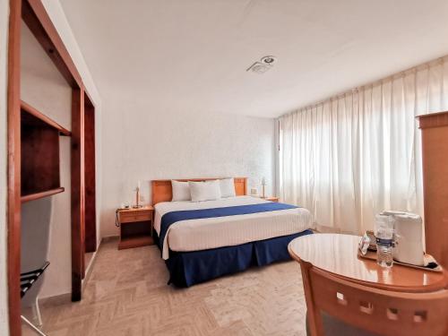 a hotel room with a bed and a table at HOTEL DON MIGUEl in Tapachula