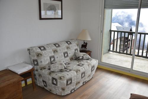 a living room with a couch and a balcony at Résidence Les Adrets de Peyragudes in Germ