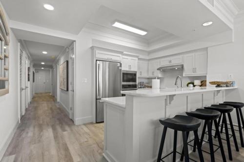 a kitchen with white cabinets and bar stools at Perdido Dunes Tower 6E condo in Orange Beach