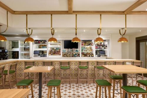 a restaurant with wooden tables and green chairs at The Westin Oaks Houston at the Galleria in Houston