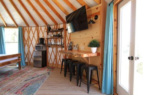 a kitchen with a bar and stools in a tent at Yurt Overlook #4 with AC and Private Bath 2 Kings in Orderville
