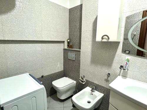 a small bathroom with a toilet and a sink at Downtown Apartment in Korçë