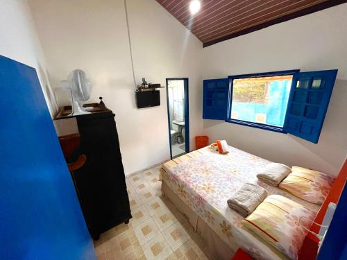 a bedroom with a bed and a window at Chalés de Triunfo in Triunfo