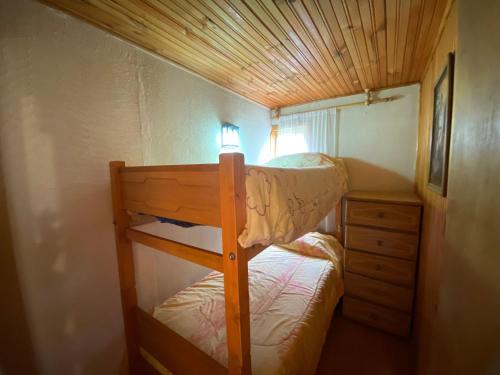 a small bedroom with a bunk bed and a dresser at Cabaña Rústica con Vista y Entorno Natural in Río Blanco