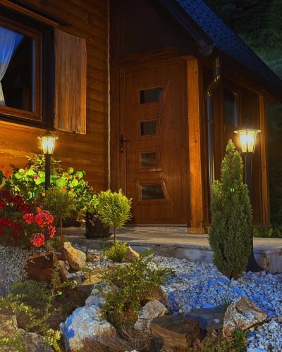 a front door of a house with a garden of flowers at Casa Mia Resort in Kupres