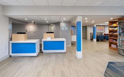 a lobby of a hospital with blue walls and wooden floors at Holiday Inn Express Rochester-Greece in Greece
