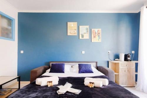 une chambre avec un grand lit aux murs bleus dans l'établissement Charmant studio près de la mer, à Cannes