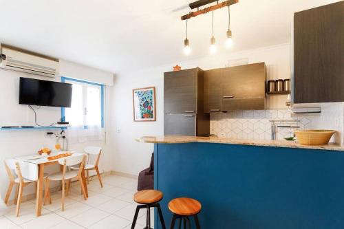 une cuisine avec un comptoir, une table et des chaises dans l'établissement Charmant studio près de la mer, à Cannes