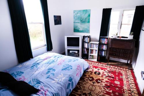a bedroom with a bed and a tv in it at Nothing Fancy 90s Queen Room in Whanganui