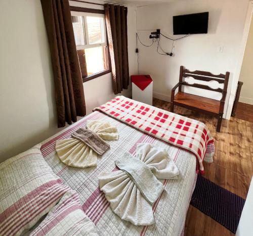 a bedroom with two beds with towels on them at Suítes Cantinho Gostoso in Lavras Novas