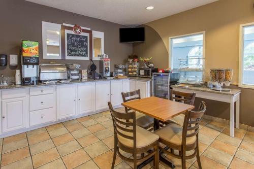 a kitchen with a table and chairs and a counter at Rock Island Inn & Suites Streator , IL in Delbert Egan Housing Project