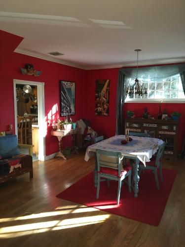 a living room with a table and red walls at Elaine's Hollywood Bed & Breakfast in Los Angeles