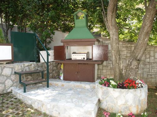 a bird house and a bench next to a wall at Apartments Matic in Njivice