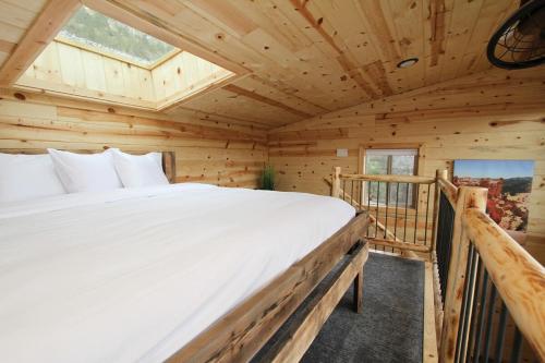 ein Schlafzimmer in einem Blockhaus mit einem großen Bett in der Unterkunft Treetop #8 at East Zion Resort in Orderville