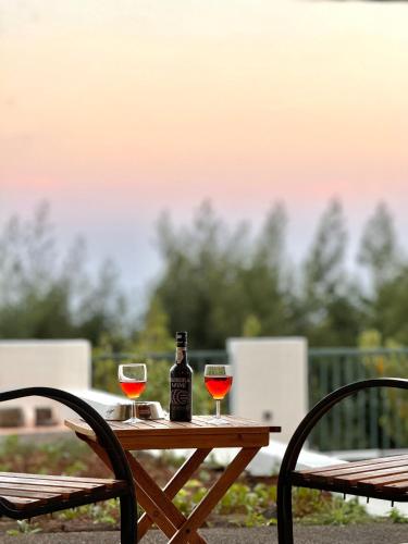a table with a bottle of wine and two glasses at Moradia Abreu in Santa Cruz