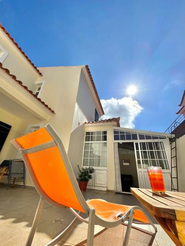 an orange chair sitting in front of a building at Moradia Abreu in Santa Cruz
