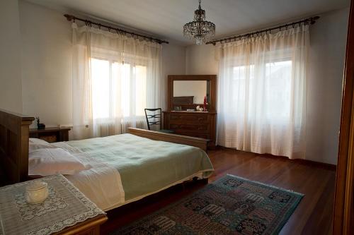 a bedroom with a bed and a dresser and a mirror at B&B Colli's Dolomites in Belluno