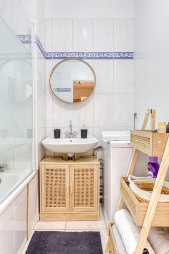 une salle de bain avec un lavabo et un miroir dans l'établissement Appartement lumineux Parking proche transport, au Bourget
