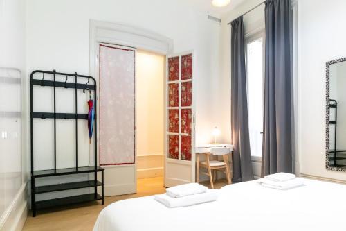 sypialnia z dwoma łóżkami, stołem i oknem w obiekcie Ever House - CHUECA-GRAN VIA w Madrycie