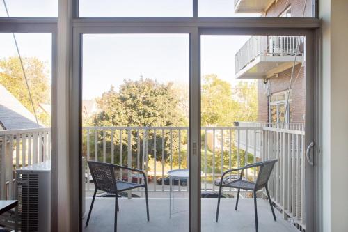 a screened porch with two chairs and a table at East Side Luxury 1BR Apt - Near Brady and Fiserv with Balcony in Milwaukee